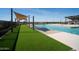 Inviting pool area with turf lawn and shade canopies creates a relaxing outdoor oasis at 15751 W Pioneer St, Goodyear, AZ 85338