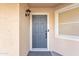 Close-up of the front door with a modern grey finish, secure lock system, and an elegant outdoor sconce at 16029 N 171St Dr, Surprise, AZ 85388