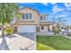 Inviting two-story home featuring stone accents, a well-manicured lawn, and a spacious two-car garage at 16029 N 171St Dr, Surprise, AZ 85388