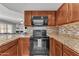 Kitchen features tile backsplash, granite counters, and wooden cabinetry at 16029 N 171St Dr, Surprise, AZ 85388