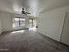 Spacious carpeted living room with large windows and a ceiling fan, leading to an outdoor patio at 16657 E Gunsight Dr # 296, Fountain Hills, AZ 85268