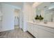 Clean bathroom with dual sinks, modern finishes, and a view into the walk-in closet at 16681 W Charlotte Dr, Surprise, AZ 85387