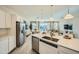 Open concept kitchen with stainless steel appliances, an island sink, and an adjacent living area at 16681 W Charlotte Dr, Surprise, AZ 85387