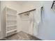 Bright walk-in closet features built-in shelving and a hanging rod with clothing and robes at 16681 W Charlotte Dr, Surprise, AZ 85387