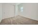 Neutral bedroom featuring plush carpet, double closet, and a bright window at 16765 W Bronco Trl, Surprise, AZ 85387