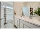 Bright bathroom with double vanity, white cabinets, and a shower-tub combo at 16781 W Bronco Trl, Surprise, AZ 85387