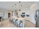 Bright kitchen featuring a large island with bar seating, stainless steel appliances, and modern pendant lighting at 16781 W Bronco Trl, Surprise, AZ 85387