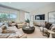 Cozy living room with a large sectional sofa, modern decor, and abundant natural light from the expansive windows at 16781 W Bronco Trl, Surprise, AZ 85387