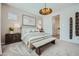 Elegant primary bedroom featuring a unique light fixture, patterned wallpaper, and cozy decor at 16781 W Bronco Trl, Surprise, AZ 85387