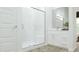 Sleek bathroom features a glass enclosed shower with marble accents, light wood flooring, and a white vanity at 17550 W Victory St, Goodyear, AZ 85338