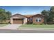 Charming single-story home featuring a brick facade, two-car garage, desert landscaping, and a tile roof at 17550 W Victory St, Goodyear, AZ 85338