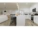 Bright, open kitchen with white cabinets, stainless appliances, and island seating, perfect for entertaining at 17550 W Victory St, Goodyear, AZ 85338