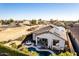 An aerial view of a backyard with a beautiful pool and covered patio, plus solar panels on the roof at 17704 W Tasha Dr, Surprise, AZ 85388