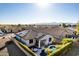 Beautiful aerial view of a home with a pool, solar panels, landscaped yard, and mountain views in the distance at 17704 W Tasha Dr, Surprise, AZ 85388