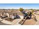 Attractive aerial view of a home with solar panels, a two-car garage, a green lawn, and neat landscaping at 17704 W Tasha Dr, Surprise, AZ 85388