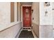 Inviting front porch with a charming red door, decorative wreath, and a 'Live, Love, Bark' sign at 17704 W Tasha Dr, Surprise, AZ 85388