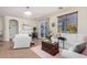 Bright living room with white furniture, tile flooring, a sliding glass door, and elegant decor at 17704 W Tasha Dr, Surprise, AZ 85388