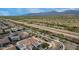 An aerial view of a house in a neighborhood near a natural desert landscape with distant mountain views at 19057 W Yucatan Dr, Surprise, AZ 85388