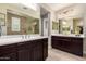 Bathroom featuring double sinks, framed mirrors and dark wooden cabinets at 19057 W Yucatan Dr, Surprise, AZ 85388