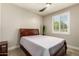 Bedroom with a wood-framed bed, ceiling fan, and shuttered window at 19057 W Yucatan Dr, Surprise, AZ 85388