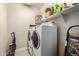 Functional laundry room with appliances, storage shelves, and beige-colored tile floor at 19057 W Yucatan Dr, Surprise, AZ 85388