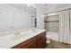 Bathroom with double sinks, wood vanity, and tiled bathtub at 1920 E Bell Rd # 1153, Phoenix, AZ 85022