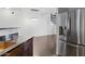 Spacious living room with dark hardwood floors and spiral staircase as seen from the kitchen with stainless steel refrigerator at 1920 E Bell Rd # 1153, Phoenix, AZ 85022