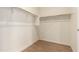 Walk-in closet with simple shelving and wooden-look flooring in neutral color palette at 2379 E San Miguel Dr, Casa Grande, AZ 85194