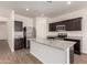 Bright kitchen with stainless steel appliances, granite counters and dark wood cabinets at 2379 E San Miguel Dr, Casa Grande, AZ 85194