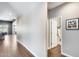 Hallway with wood-look tile flooring leading to various rooms, including a bathroom with a view of the backyard at 26020 N 138Th Ln, Peoria, AZ 85383