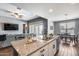 Open kitchen with island seating, stainless steel sink, and view into the living room at 26020 N 138Th Ln, Peoria, AZ 85383