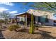 Landscaped backyard featuring desert plants, gravel, and a covered patio with seating at 26509 W Ponderosa Ln, Buckeye, AZ 85396