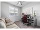 Bright bedroom featuring a ceiling fan, home office, and window with plantation shutters at 26509 W Ponderosa Ln, Buckeye, AZ 85396