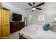 Bedroom featuring dark wood dresser, ceiling fan, TV, and plush bedding for a cozy feel at 26509 W Ponderosa Ln, Buckeye, AZ 85396