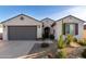 Charming single-story home showcasing a stucco exterior, desert landscaping, and a gray two-car garage at 26509 W Ponderosa Ln, Buckeye, AZ 85396