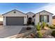 Charming single-story home showcasing a stucco exterior, desert landscaping, and a gray two-car garage at 26509 W Ponderosa Ln, Buckeye, AZ 85396