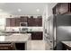 Modern kitchen with stainless steel appliances, granite countertops, and dark wood cabinets at 26509 W Ponderosa Ln, Buckeye, AZ 85396