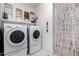 Bright laundry room with washer, dryer, and overhead shelving for storage at 26509 W Ponderosa Ln, Buckeye, AZ 85396