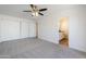 Spacious bedroom features neutral carpet, ceiling fan, and a view to the ensuite bathroom at 2728 W Redfield Rd, Phoenix, AZ 85053