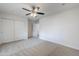 Large bedroom features neutral carpet, ceiling fan, and sliding door closet in a neutral color palette at 2728 W Redfield Rd, Phoenix, AZ 85053