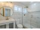 Bathroom featuring marble tile shower with glass enclosure, gold hardware, and white vanity at 2749 E Wier Ave, Phoenix, AZ 85040