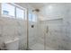 Bathroom shower with marble look tile surround, built-in niche, glass door and gold hardware at 2749 E Wier Ave, Phoenix, AZ 85040