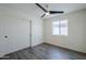 This bedroom features a modern ceiling fan, window, gray wood floor, and large sliding door closet at 2749 E Wier Ave, Phoenix, AZ 85040