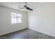 This bedroom features a modern ceiling fan, window, and gray wood floor at 2749 E Wier Ave, Phoenix, AZ 85040