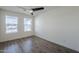 Bedroom with dark wood-look flooring, ceiling fan and dual windows for natural light at 2749 E Wier Ave, Phoenix, AZ 85040