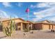 Exterior view of home boasting a three-car garage, xeriscaping, and an American flag at 3408 W Taro Ln, Phoenix, AZ 85027