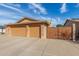 Large three-car garage exterior with a paved driveway, brick accents, and a wooden gate at 3408 W Taro Ln, Phoenix, AZ 85027