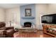 Cozy living room showcasing a stone fireplace with a blue mantel and hardwood floors at 3408 W Taro Ln, Phoenix, AZ 85027