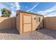 Tan-painted outdoor storage shed featuring a window and compass design, surrounded by gravel at 3408 W Taro Ln, Phoenix, AZ 85027