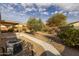 Landscaped backyard featuring desert landscaping, a covered patio, and a concrete walkway at 3896 E Aragonite Ln, San Tan Valley, AZ 85143